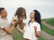 A joyful family moment outdoors with parents playing with their daughter.